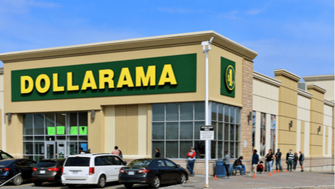 Dollarama store with people lined up outside during pandemic. 