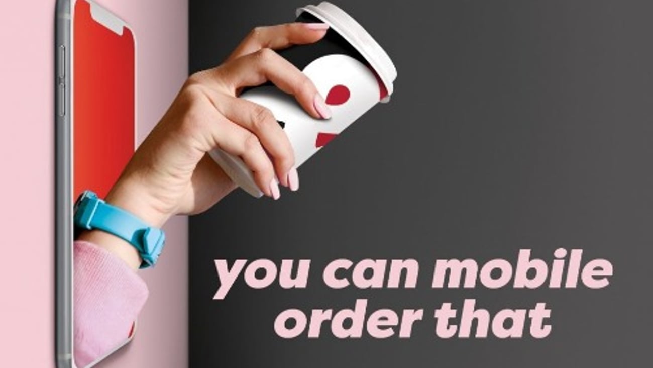 hand with coffee cup reaching out of phone