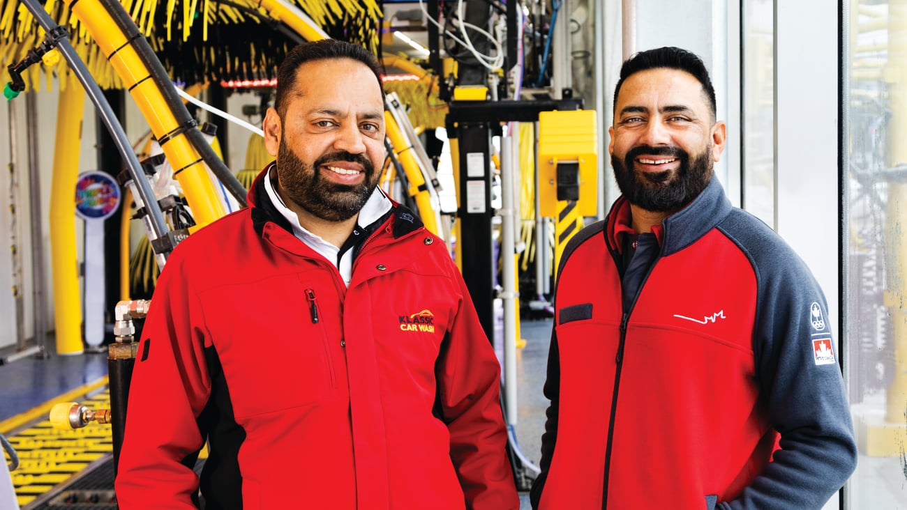Tony Thind and Rozy in front of Klassic Car Wash's automatic carwash system.