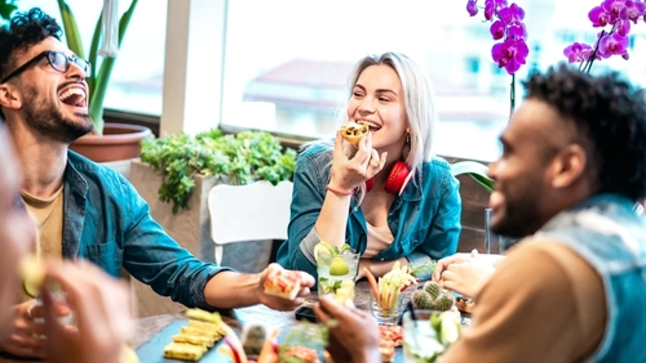 ulticultural friends eating together at luxury pub restaurant - Life style concept with trendy multiracial people having fun on happy hour at bar eatery - Vivid filter with focus on central woman