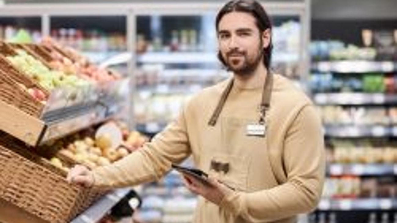 Convenience store employee putting out fresh food stock image