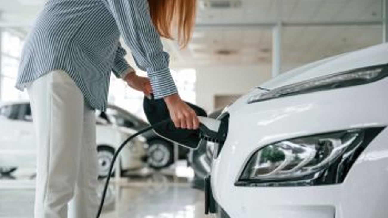 Woman Charging EV Stock Image Teaser