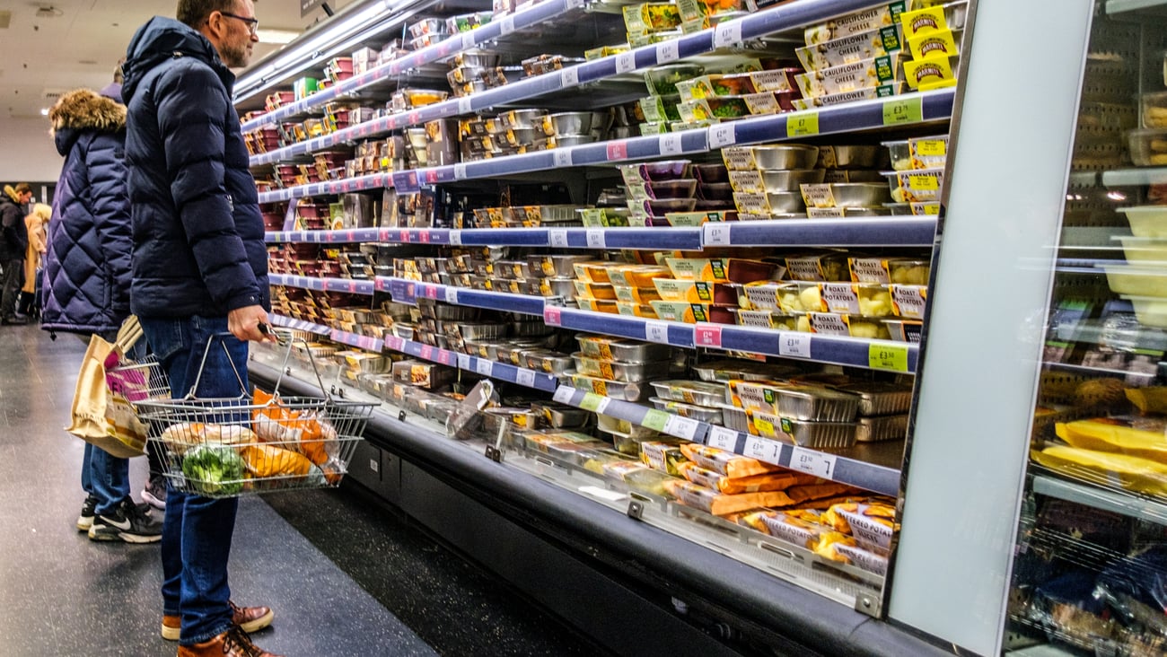 white male looking at food shelves in store