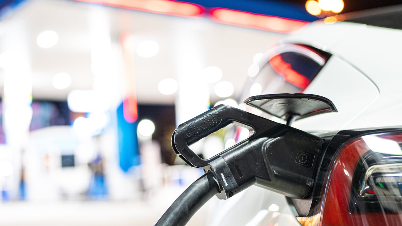 gas pump in EV car, station in the background