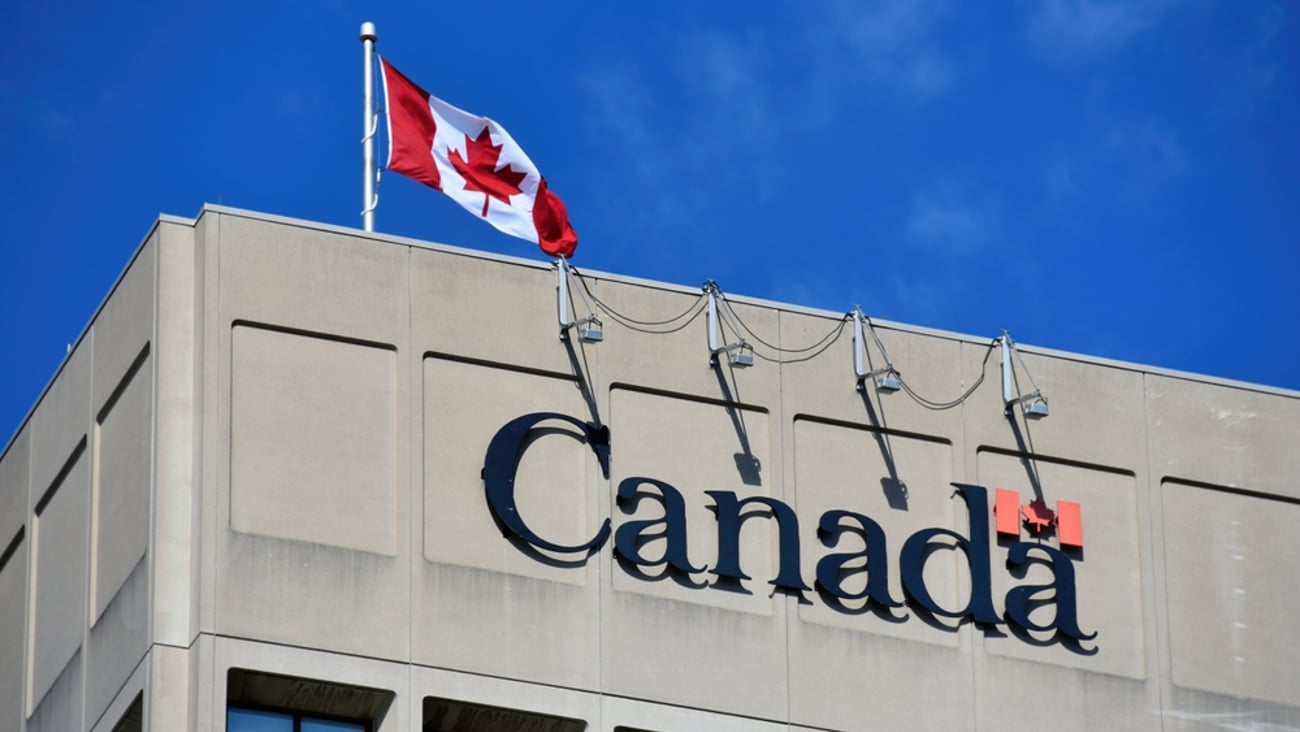 Close up of the corner of a Canadian government building with Canadian flag on the roof.