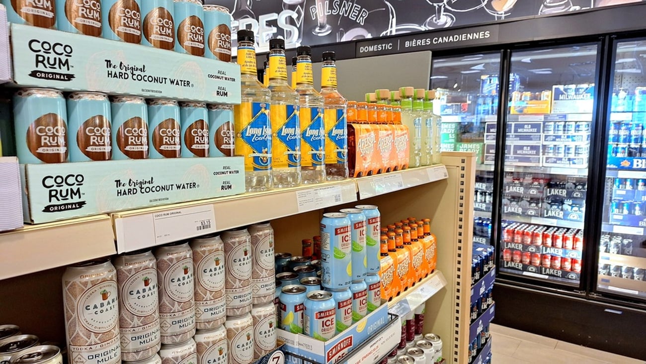 Shelves stocked with Canadian alcohol products and refrigerated drinks in background
