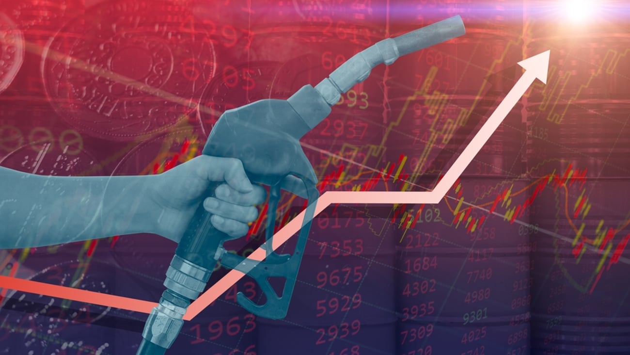 A hand with a gas nozzle in front of a climbing graph indicating the rising cost of graph