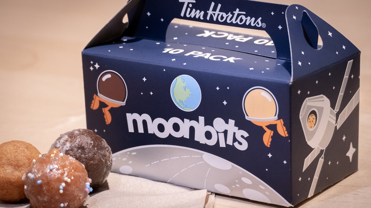 Box of Tim Hortons "Moon bits" box with a few Timbits in front of it.