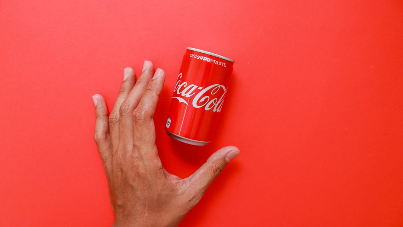 hand reaching for Coca-Cola mini can