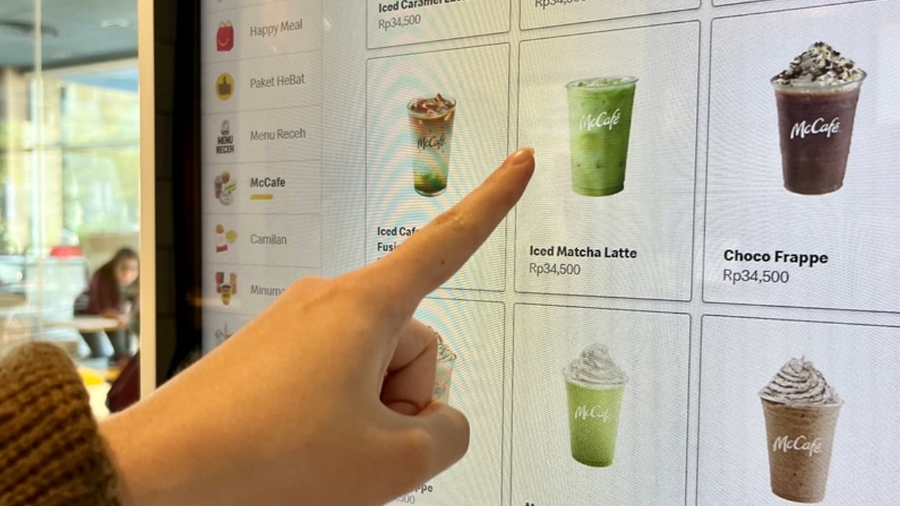hand selecting a drink from McDonald's electronic drinks menu