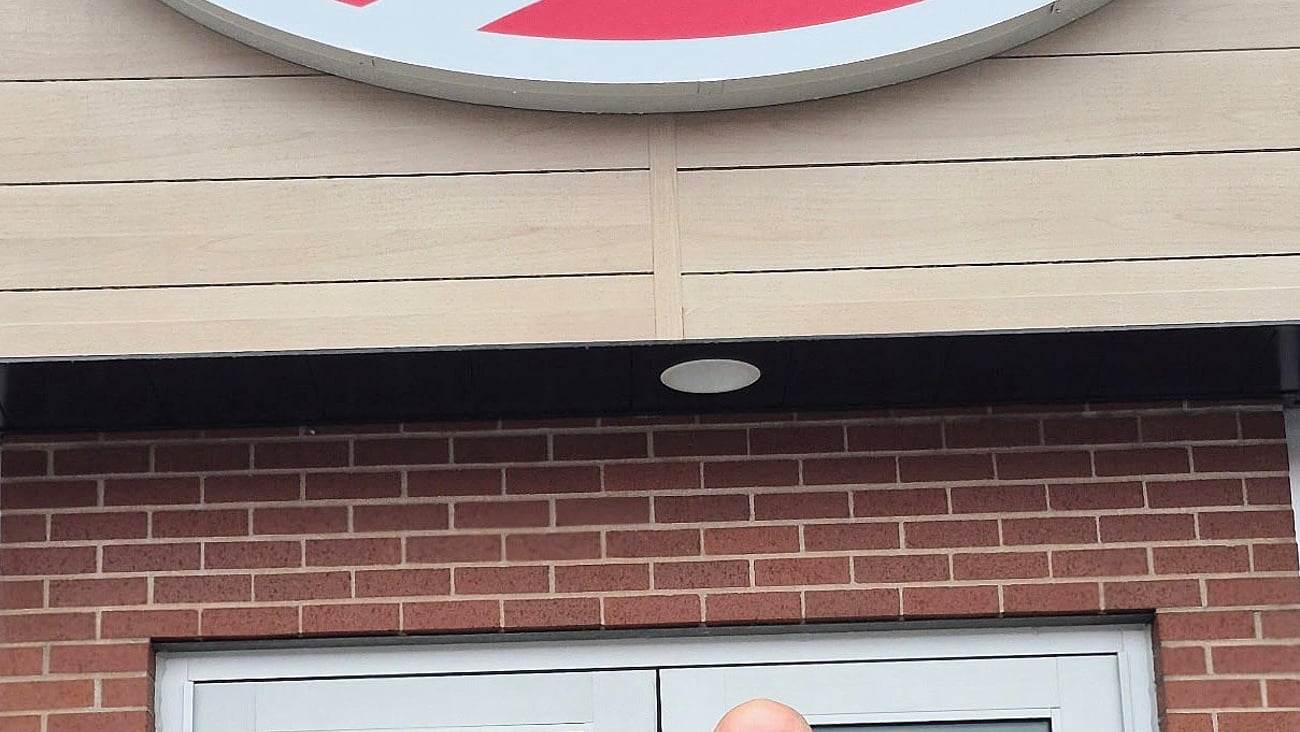 Unnamed owner stands in front of Mel's convenience store.