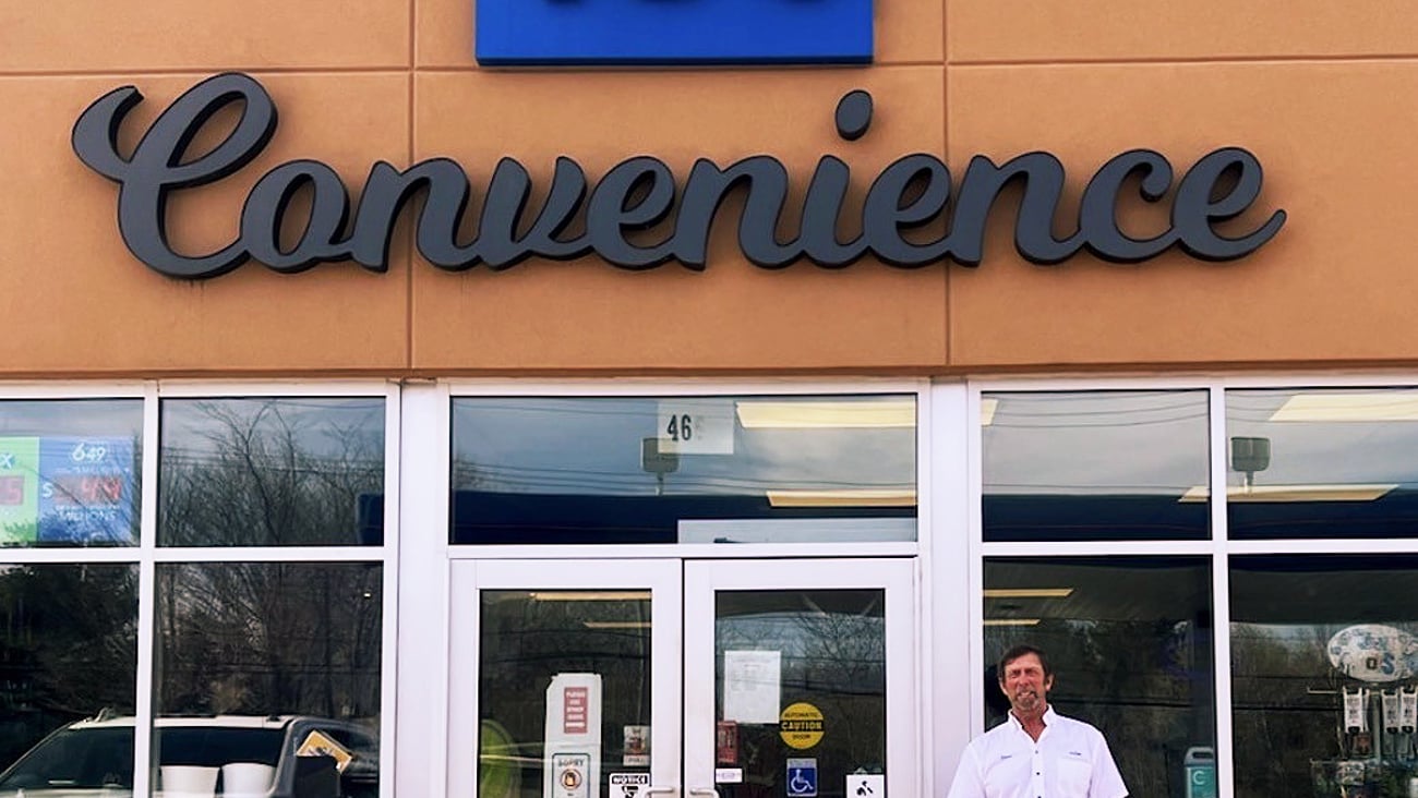 Stephen Morine, owner, stands in front of his store, TJ's Convenience
