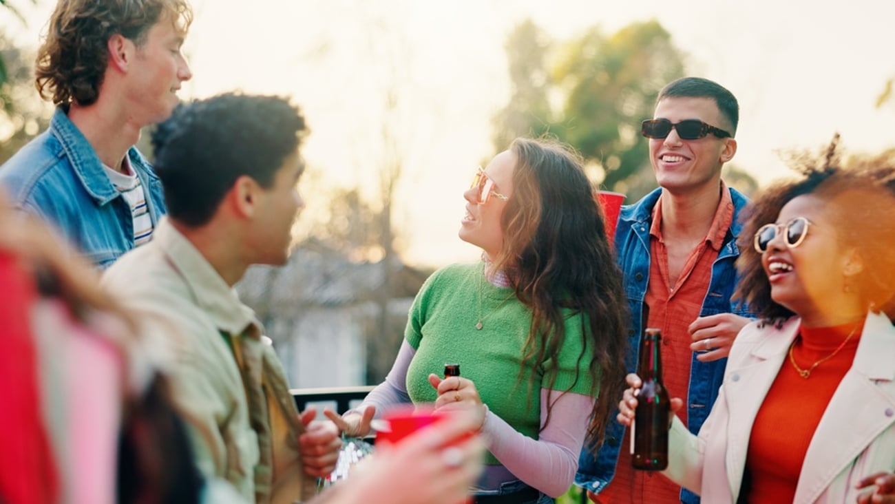 group of young people drinking alcohol outdoors