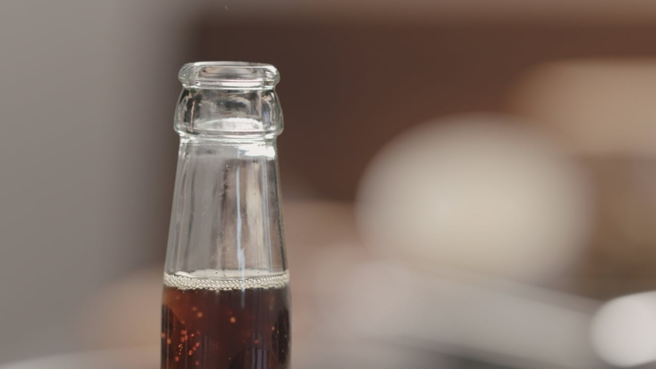 close up of the neck of an uncapped soda bottle  