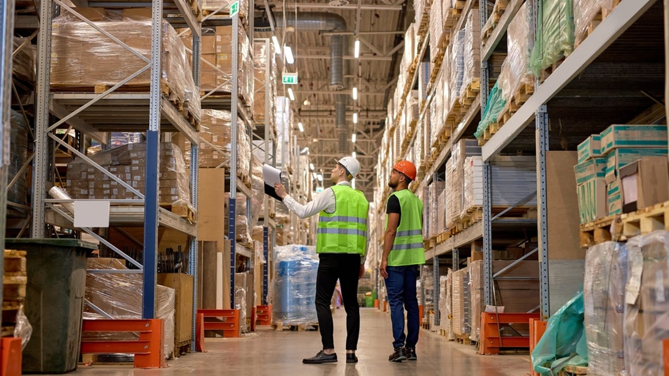 Two men in a warehouse, looking through their inventory