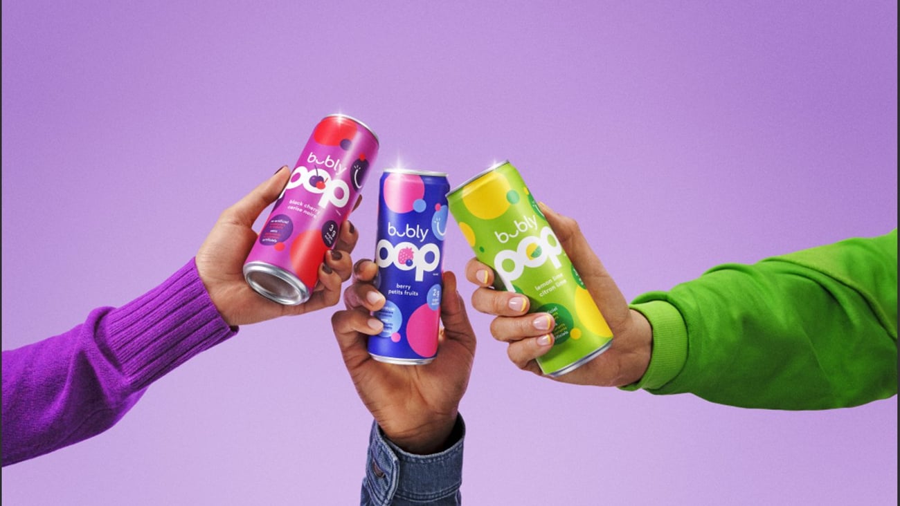 Three arms, each holding a different flavour of Bubly Pop