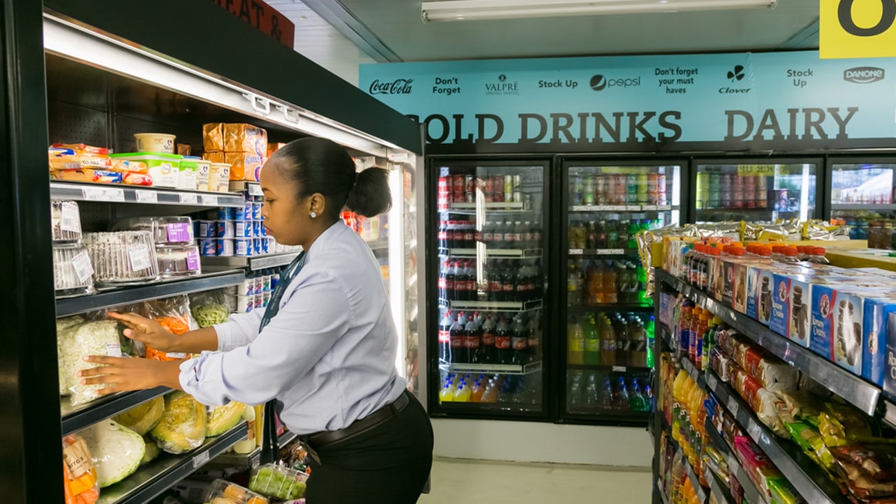woman shopping in front of refrigerated shelves