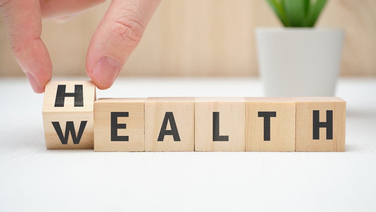 Concept health wealth on wooden block hold hand. Close up.