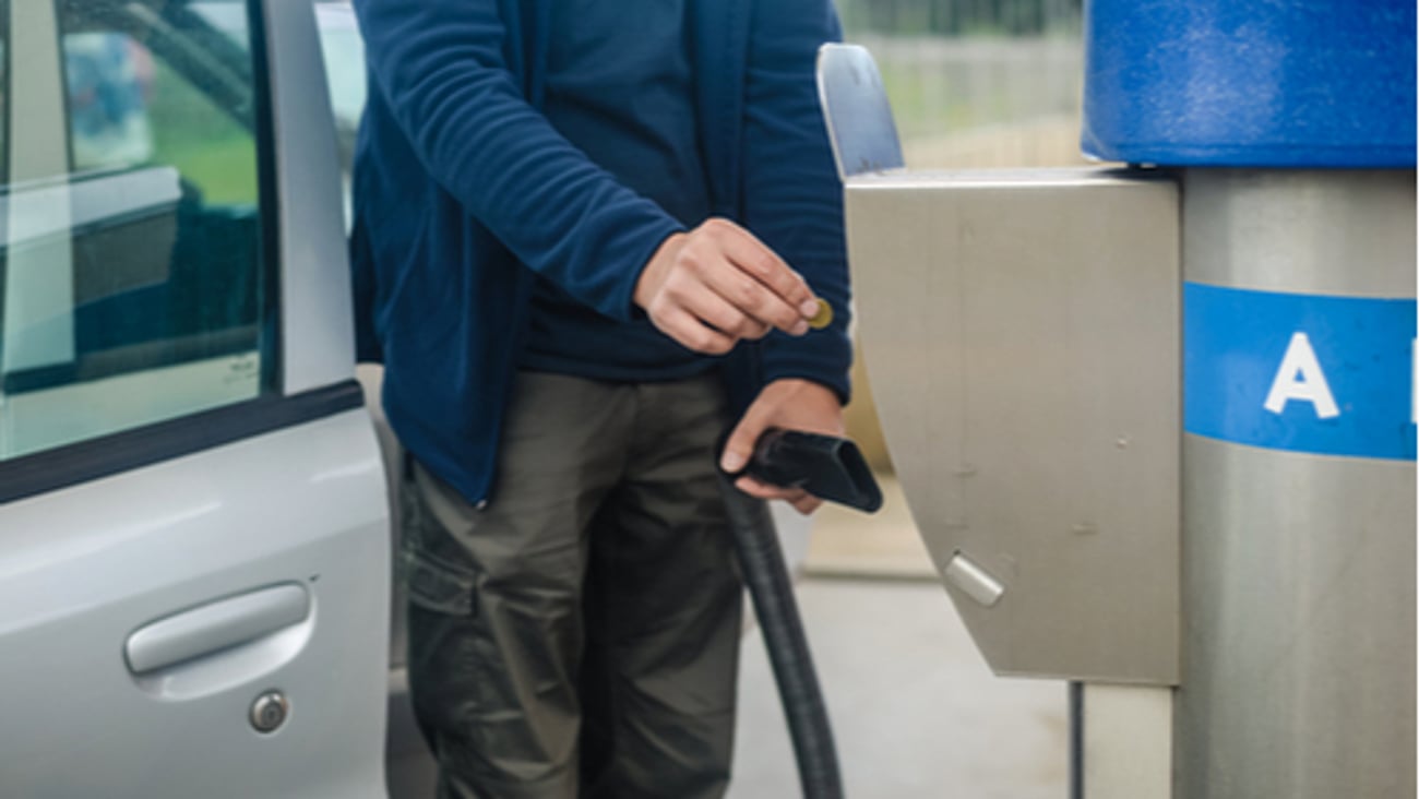 Person paying coins to self service automatic car vacuum machine. cleaning concept.