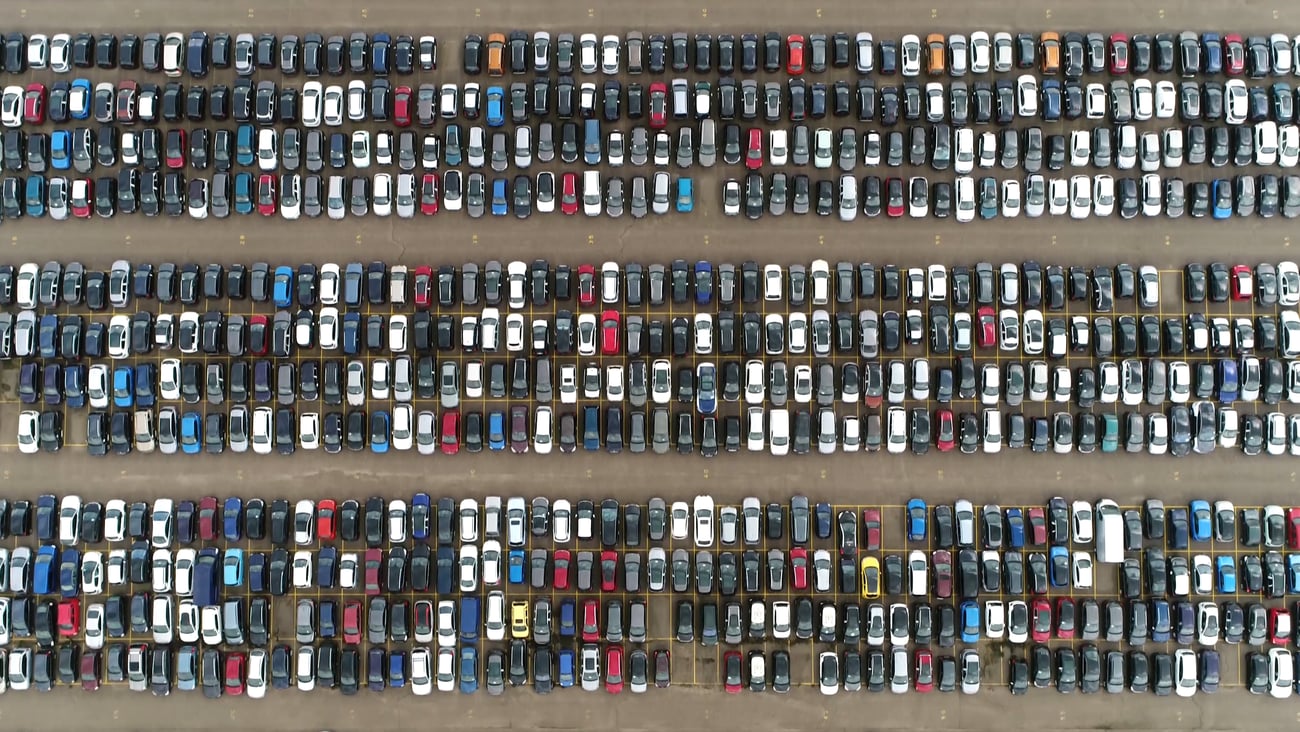 Aerial top down picture of automaker car lot showing vehicles parked close to each other ready for further distribution