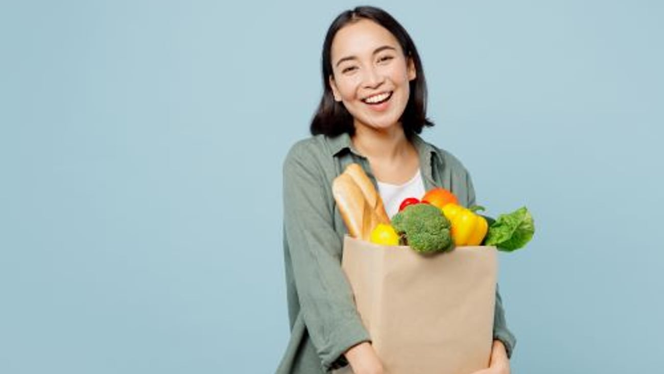 Happy female shopper with grocery bag