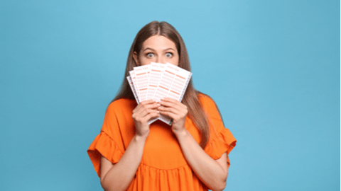 excited woman holding lottery tickets in front of her face