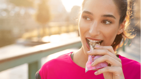 woman eating a protein bar