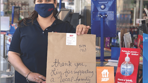 Little Short Stop Stores employee writes a personal note on the deliver item bag. 