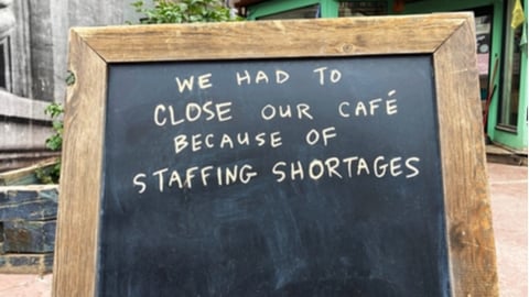 Staffing shortages sign at closed business due to lack of staff, employee shortage