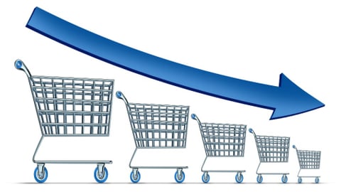 Sales decline symbol as a group of shrinking shopping carts with a blue arrow going down as a metaphor for commercial retail consumerism on a white background.