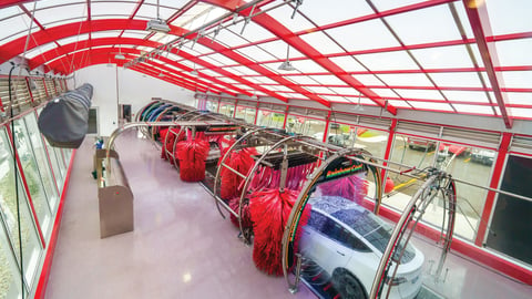 Interior shot from above of a car moving through the car wash tunnel