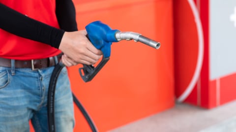 Man  hand holding nozzle to refuel the car