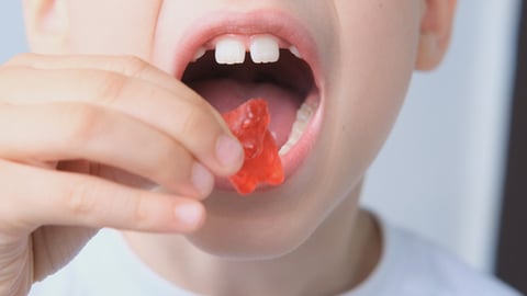 child putting a gummy bear in their mouth