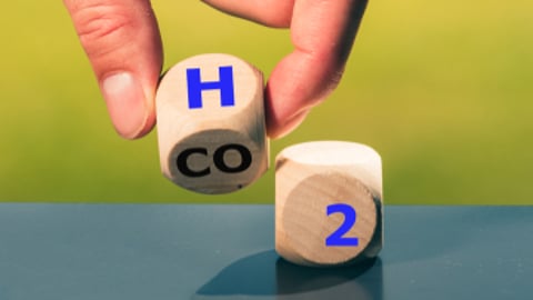 Two game pieces containing the letter H and number 2 side by side on a green background.