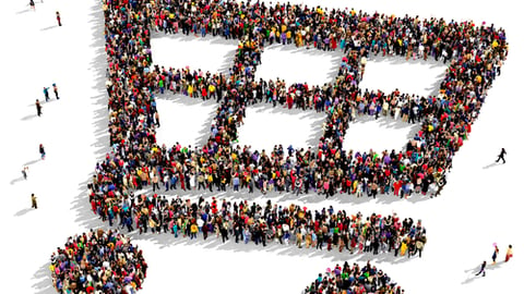 Large group of people seen from above gathered together in the shape of a shopping cart