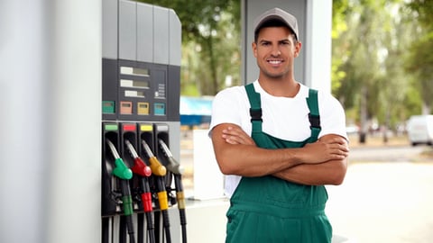 Worker in uniform at modern gas station