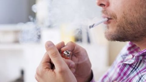 Man smoking a cigarette with a lighter stock image