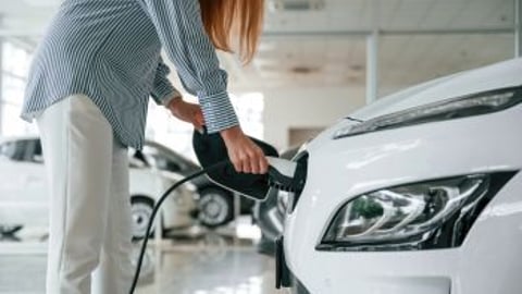 Woman Charging EV Stock Image Teaser