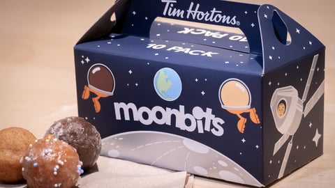 Box of Tim Hortons "Moon bits" box with a few Timbits in front of it.