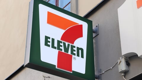 Close up of exterior of an unlit 7-Eleven neon sign in the day.