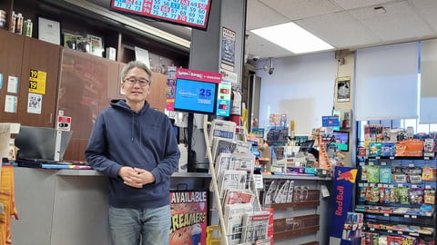 Sean Lee stands in front of the counter in his store, Seafair Smoke & Mixers