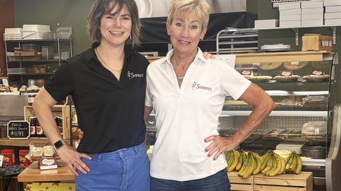 Kayla Helliker (left) and Sherry Mowat (right) owners of Sherry's convenience store standing inf fornt of a selection of baked goods. 