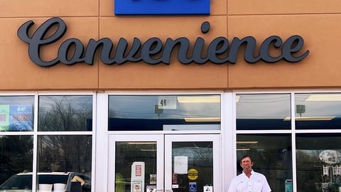 Stephen Morine, owner, stands in front of his store, TJ's Convenience