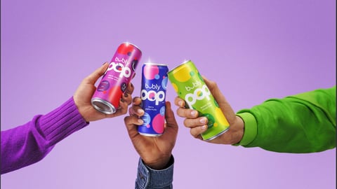 Three arms, each holding a different flavour of Bubly Pop
