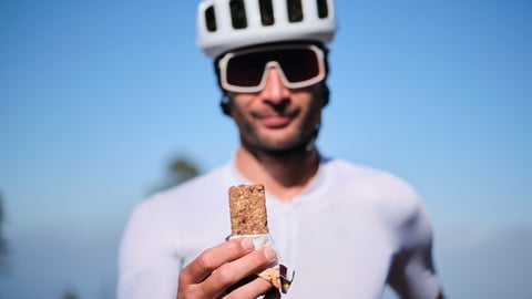 cyclist holding up a granola bar