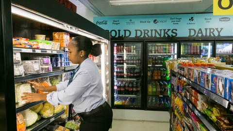 woman shopping in front of refrigerated shelves