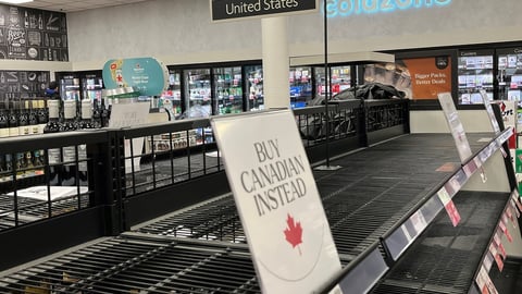 Empty liquor store shelves with "Buy Canadian Instead" sign
