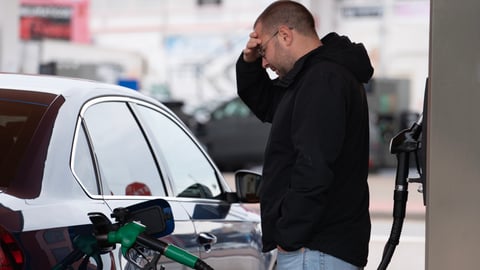 frustrated man pumping gas