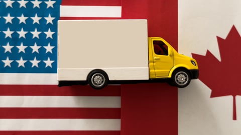 Truck between Canadian and American flags