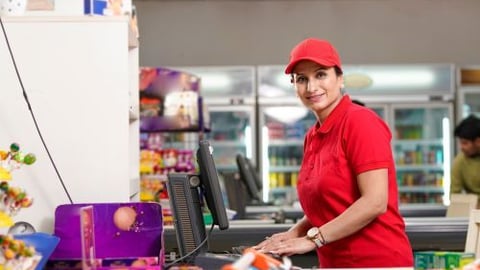 Woman in store uniform at cash register